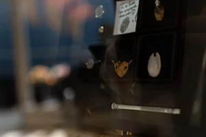 Présentation de bijoux cinéraires et médaillons d'empreinte dans une vitrine.