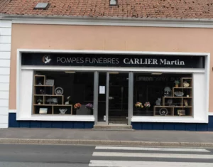 Devanture de l'agence de pompes funèbres Carlier Martin avec articles en vitrine.
