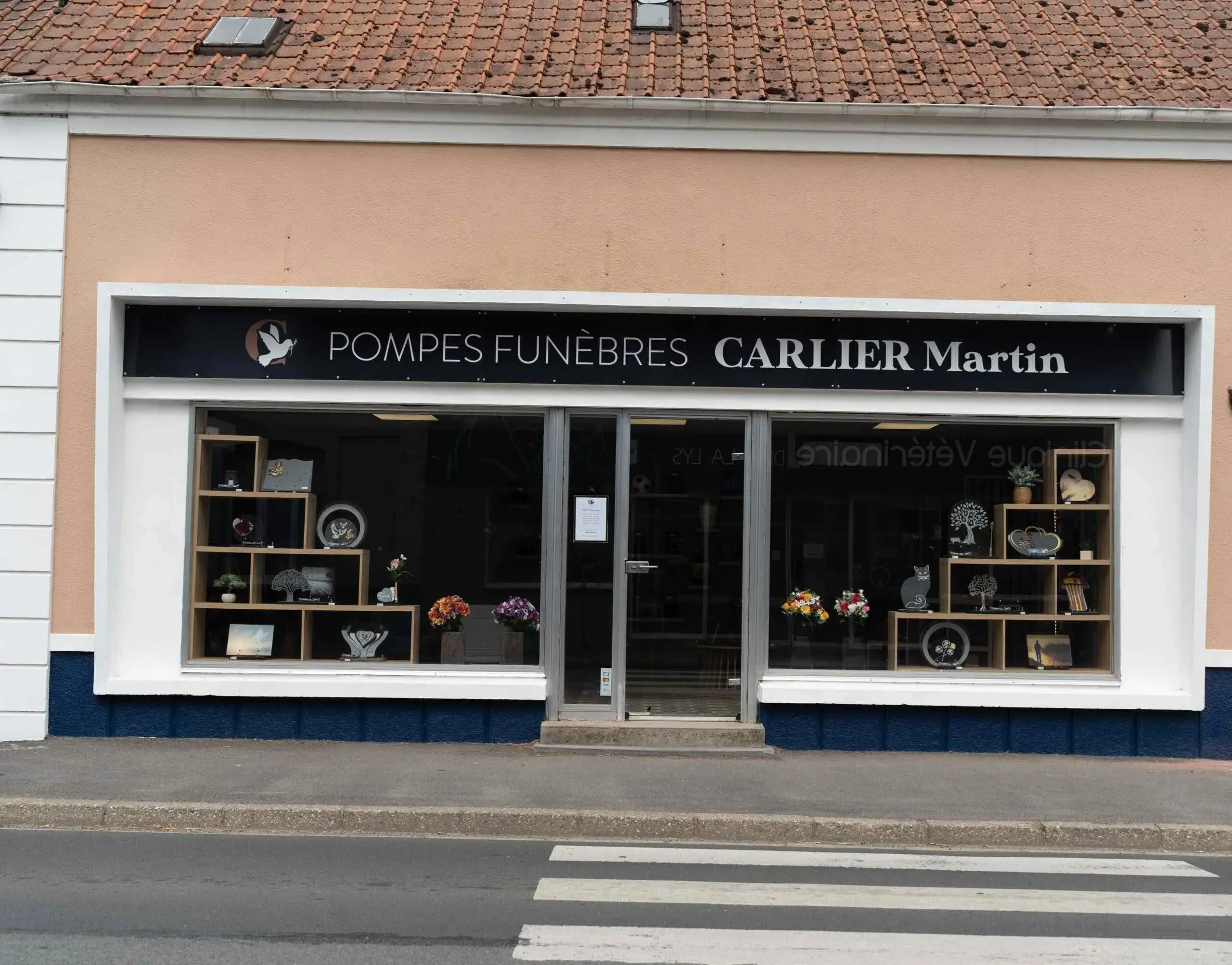 Devanture de l'agence de pompes funèbres Carlier Martin avec articles en vitrine.